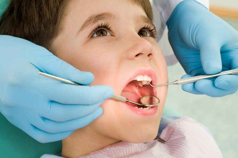 A dentist examining a child’s mouth during a dental visit